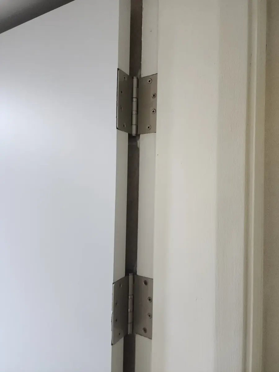 집 문 교체 — 새 문짝과 문틀을 잇는 경첩